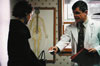 Katie's doctor (Richard Ferrone) hands her a referral card.
